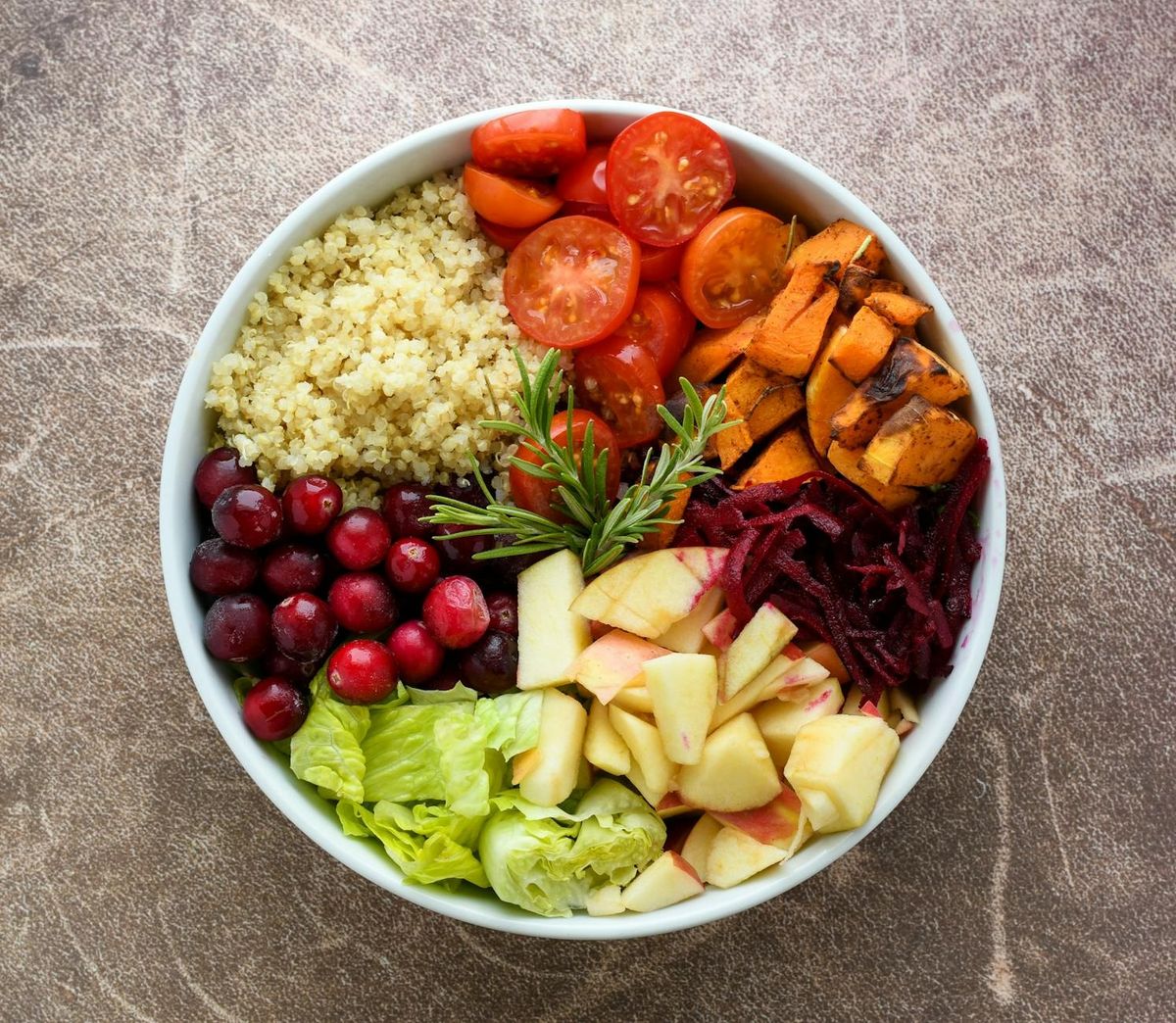 A vibrant Buddha bowl filled with quinoa, fresh fruits, and vegetables.