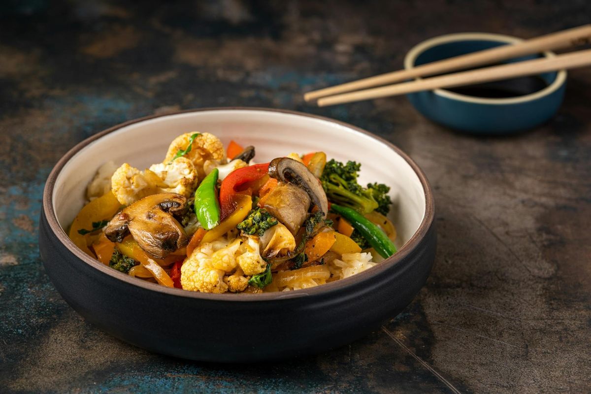Savor this flavorful mixed vegetable dish served with rice in a stylish bowl.
