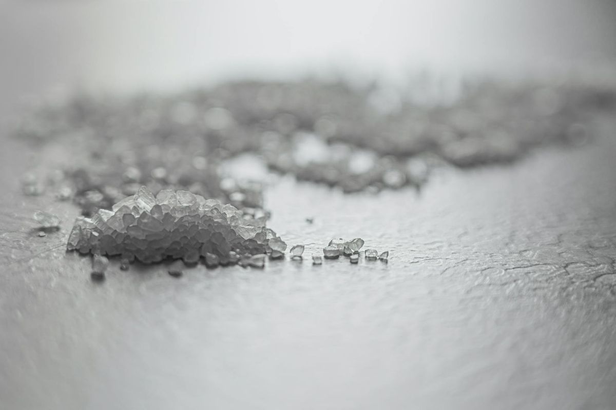 Coarse rock salt scattered on a textured surface.
