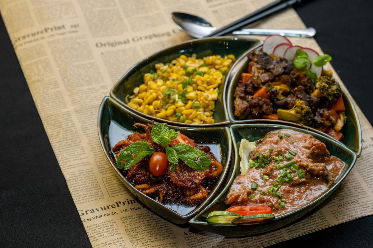 Colorful four-section meal with diverse dishes beautifully arranged on a platter.