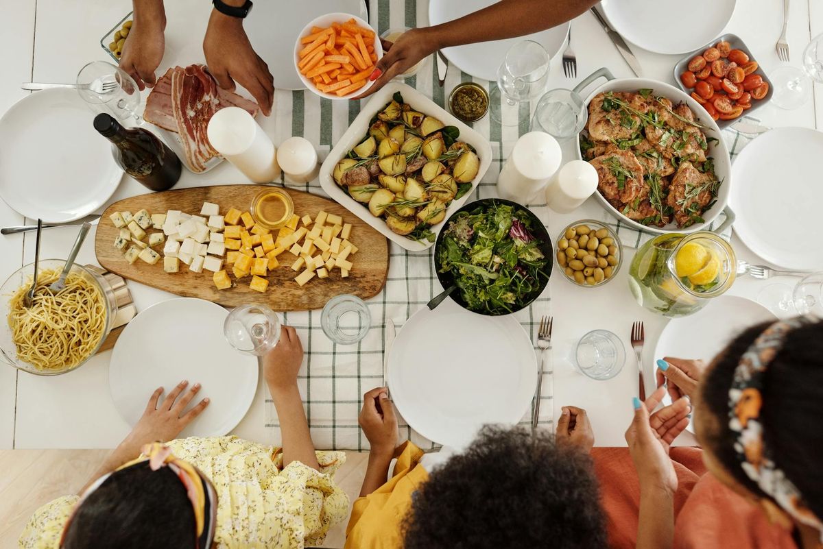 Family enjoying a diverse meal with assorted dishes, olives, and salad.